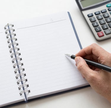 A cozy workspace with a laptop, notebook, and a cup of coffee, bathed in natural light.