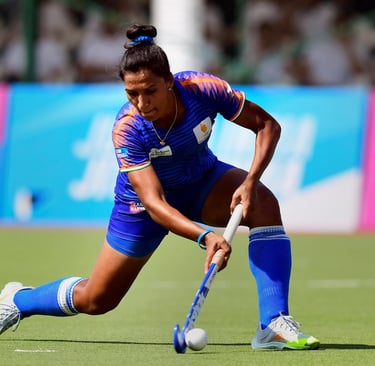 Rani Rampal taking a powerful hockey shot on the field.