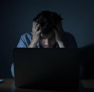Stressed person facing blank laptop screen, showing emotional avoidance and procrastination.