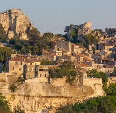 Medieval stone village of Les Baux-de-Provence perched on a rocky hilltop in France at sunset.