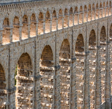 Ancient aqueduct bridge with stone arches, showcasing historic masonry and architectural engineering.