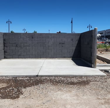 Charcoal colored CMU trash enclosure with precast concrete cap
