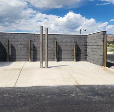 Charcoal colored double trash enclosure with precast concrete cap