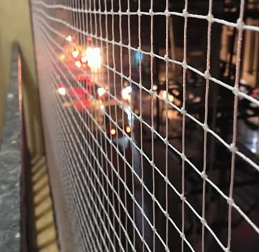 Close-up of a installed balcony safety net tightly secured on a high-rise apartment in Bengaluru.