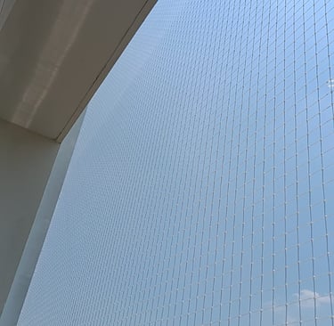 Close-up of a freshly installed balcony safety net securing a high-rise apartment.