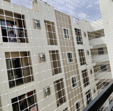 Close-up of a freshly installed white balcony safety net against a sunny sky background