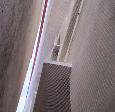 Technician carefully fitting a duct net in a narrow duct space, highlighting precision work.