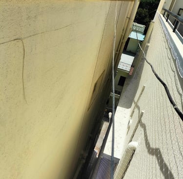 Panoramic shot of Haralur neighborhood showcasing several buildings with duct nets installed.
