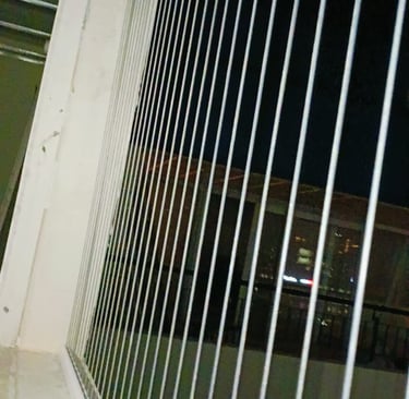 Close-up view of a freshly installed clear invisible grill on a balcony in Bengaluru.