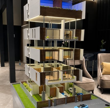 Detailed architectural scale model of a modern multi-story luxury apartment building featuring realistic lighting 