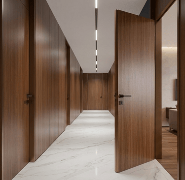 Modern long hallway featuring dark wood paneling, marble flooring, and integrated linear LED ceiling lighting.