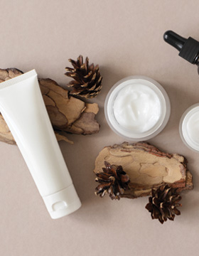 A bottle of liquid beauty product with a clear shrink band seal around the cap to prevent shipping l