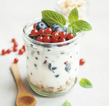 Glass with curd, blue berry, mint and spoon on the side