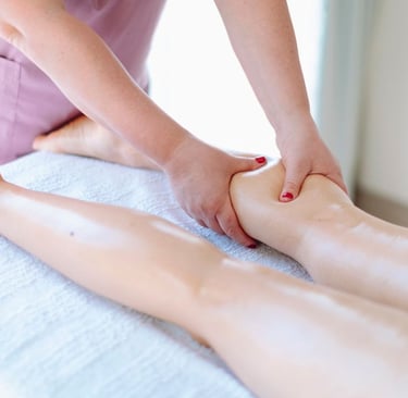 Masajista profesional realizando un masaje de tejido profundo en las piernas de un cliente