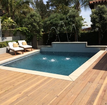 a pool with a wooden deck and a 3 separate water features