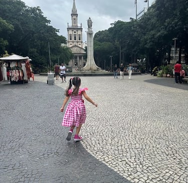 Pequena Victoria correndo pelo Largo do Machado.