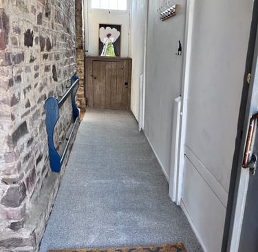 Completed stone hallway with new flooring and clean, finished walls.