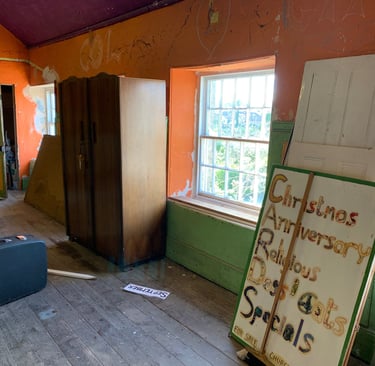 Transitional space showing partially stripped walls and renovation materials.