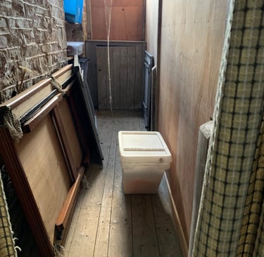 Narrow stone corridor with temporary fixtures during renovation