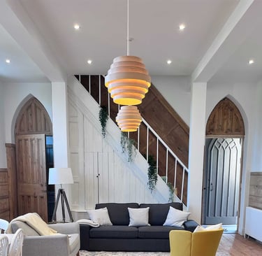 Completed staircase and living space with vaulted ceiling and feature lighting.