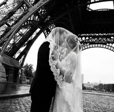 Pareja de novios casados bajo la estructura de la Torre Eiffel en París, fotografía artística