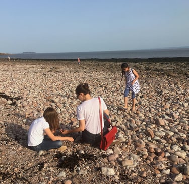 home educated children playing with mum on a beach