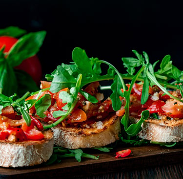 Traditionelle italienische Tomaten-Bruschetta mit frischem Rucola und Basilikum auf geröstetem Brot.