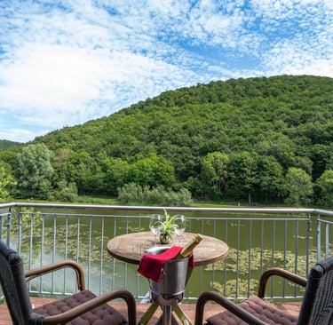 Balkon eines Hotels mit Blick auf den See und die umliegende Natur, professionell fotografiert.