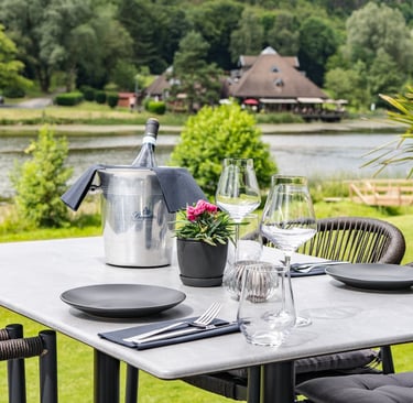 Eleganter Outdoor-Esstisch zum Mittagessen mit Weinkühler und Blick auf See und Hügel.