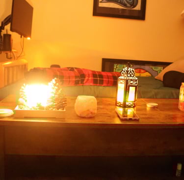 Low light candlelit living room with candles glowing on a wooden table and a sofa in the background.
