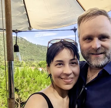 A couple standing together in a forested area in Vietnam during post surgery recovery