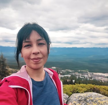 Self-portrait on a mountain overlooking Big White, British Columbia, under a cloudy sky.