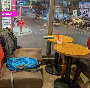 Backpack and laptop at Highland coffeeshop overlooking a city intersection in Da Lat Vietnam