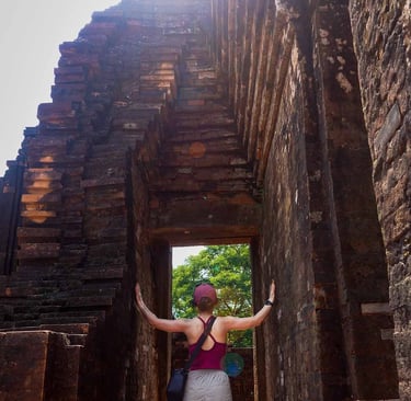 person standing inside ancient temple doorway with sunlight at my son sanctuary vietnam