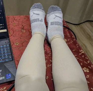 Leg compression sleeves during post surgery recovery with laptop nearby