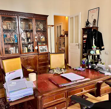 bureau d'avocat avec meubles anciens, bibliothèque, robe d'avocat, dossiers.