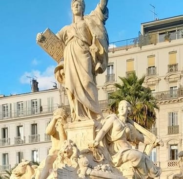 Statue de la Liberté, fontaine à Toulon sur la place, avec immeubles haussmanniens en arrière-plan.