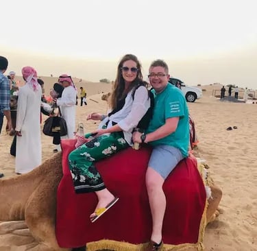 Couple enjoying a camel ride in the Dubai desert during a desert safari