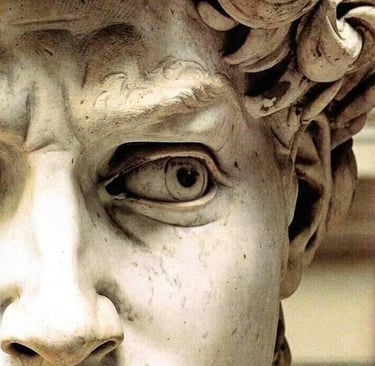 Extreme close-up of Michelangelo's David statue showing detailed eye, brow, and marble texture.