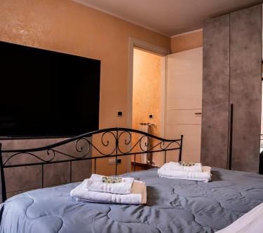 Camera matrimoniale del trilocale con TV e armadio, ideale per famiglie