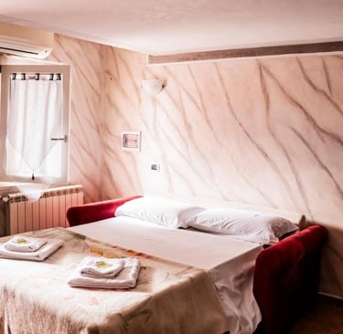 Zona notte del monolocale con letto matrimoniale e ambiente luminoso