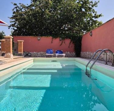 Piscina esterna condivisa, immersa nel verde vicino agli alloggi