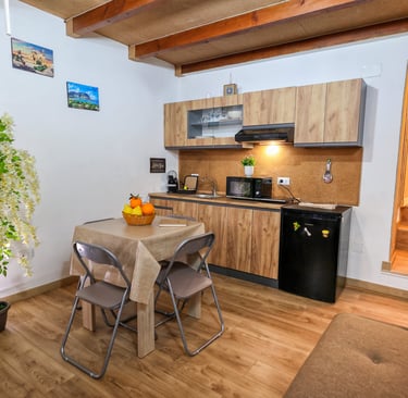 Cucina completa con piano cottura. microonde, macchina caffe', tavolo e sedie