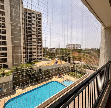 Wide-angle view of a spacious apartment balcony fully covered with pigeon netting.