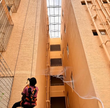 Wide shot of a balcony safety net protecting children playing in Electronic City.