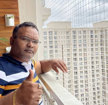 A friendly technician installing pigeon netting on a balcony in Bangalore.