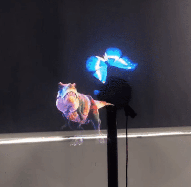 A high-tech 3D hologram fan projector displaying a glowing blue butterfly and a Tyrannosaurus Rex.