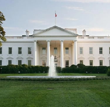 a large white house with a fountain in front of it