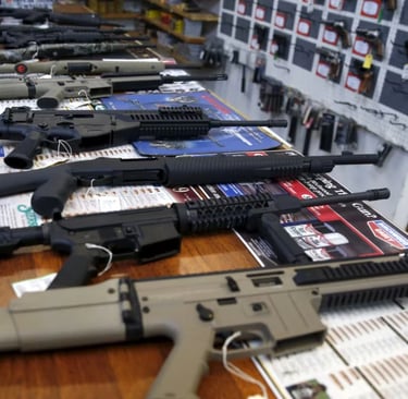 guns are lined up on a table in a store