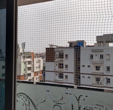 Close-up of a freshly installed pigeon net on an apartment duct in Velacherry